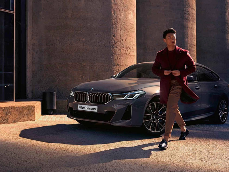 Ein Businesskunde vor einer BMW Limousine